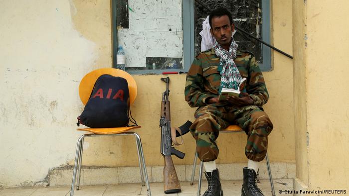 A soldier with the Tigrayan forces reads a book as he guards the headquarters of the Tigrai Mass Media Agency in Mekelle