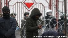Migrants stand in front of a fence in a camp on the Belarusian-Polish border in the Grodno region, Belarus November 17, 2021. Maxim Guchek/BelTA/Handout via REUTERS ATTENTION EDITORS - THIS IMAGE HAS BEEN SUPPLIED BY A THIRD PARTY. NO RESALES. NO ARCHIVES. MANDATORY CREDIT.