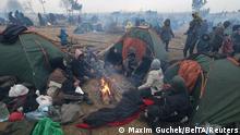 Migrants gather in a camp on the Belarusian-Polish border in the Grodno region, Belarus November 17, 2021. Maxim Guchek/BelTA/Handout via REUTERS ATTENTION EDITORS - THIS IMAGE HAS BEEN SUPPLIED BY A THIRD PARTY. NO RESALES. NO ARCHIVES. MANDATORY CREDIT.