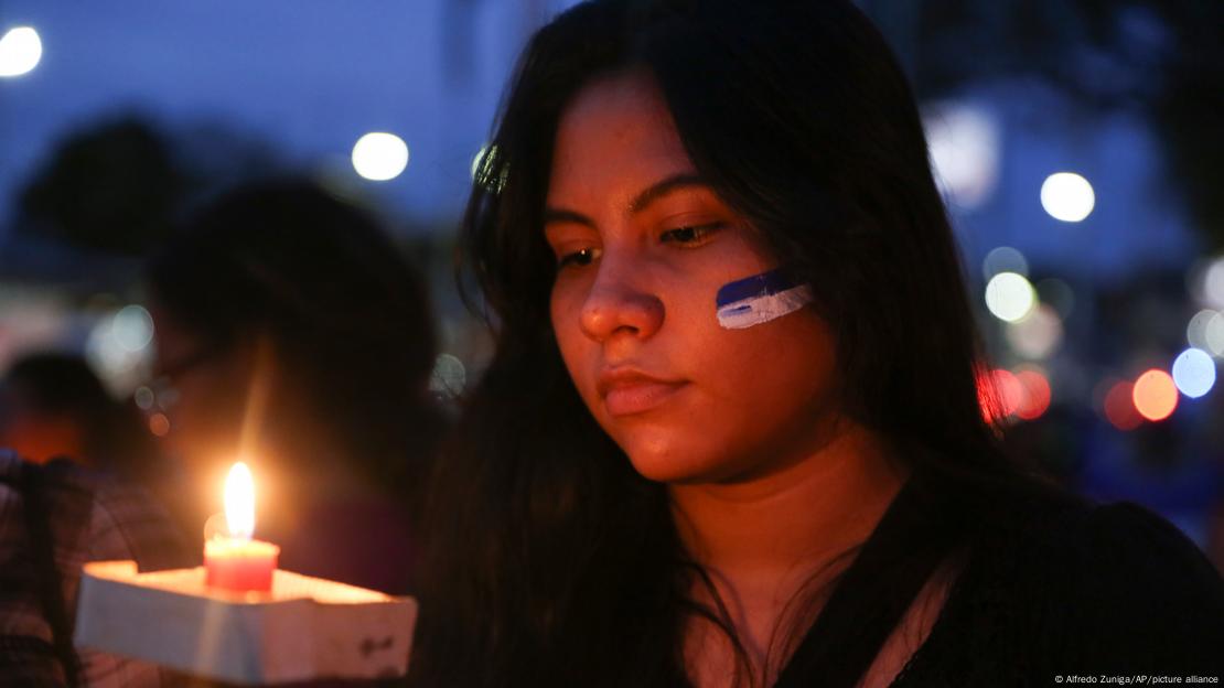 Una joven sostiene una vela en la mano como homenaje y protesta contra la represión por parte del gobierno en Nicaragua.