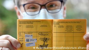 Обладатель паспорта вакцинации показывает наличие там штампа о прививке от коронавируса