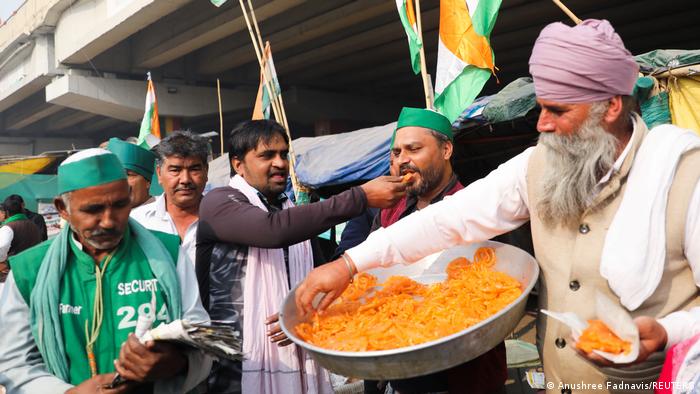 Farmers feed each other sweets while celebrating at Ghazipur on the Delhi-UP border after the news of laws being repealed.