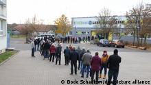 Zahlreiche Menschen stehen in einer Wartereihe vor der Turnhalle einer Schule. Hier führt die Kassenärztliche Vereinigung Thüringen ein mobiles Impfen durch.