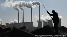 TOPSHOT - A worker uses a torch to cut steel pipes near the coal-powered Datang International Zhangjiakou Power Station at Zhangjiakou, one of the host cities for the 2022 Winter Olympics, in China's northern Hebei province on November 12, 2021. (Photo by GREG BAKER / AFP) (Photo by GREG BAKER/AFP via Getty Images)