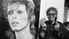 Fotograf Mick Rock posiert vor einem David Bowie-Plakat und zeigt beide Mittelfinger Fotograf Mick Rock posiert vor einem David Bowie-Plakat und zeigt beide Mittelfinger