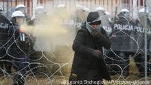 16.11.2021, Grenze Polen/Belarus, Polish serviceman sprays tear gas during clashes between migrants and Polish border guards at the Belarus-Poland border near Grodno, Belarus, on Tuesday, Nov. 16, 2021 | Photo: Leonid Shcheglov/AP/picture-alliance