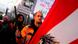 Manifestante segura tocha e outro carrega cartaz contra vacinação.