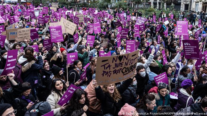 A photo showing hundreds of protesters carrying purple placards