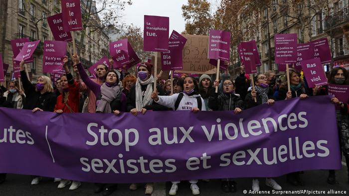 Protesters carrying a banner that reads Stop sexist and sexual violence