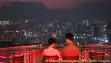 TOPSHOT - People dine at the top of a Hanoi rooftop restaurant in Hanoi on November 21, 2021. (Photo by Manan VATSYAYANA / AFP) (Photo by MANAN VATSYAYANA/AFP via Getty Images)