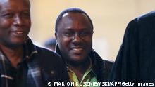 Claude Muhayimana (C), one of the two Rwandan men accused of taking part in the massacre of ethnic Tutsis during the Rwandan genocide, arrives for an extradition hearing at the courthouse in Paris, on November 13, 2013. - A French appeals court today approved the extradition of two Rwandans wanted by Kigali for their alleged role in the 1994 genocide that claimed some 800,000 lives. The ruling on Claude Muhayimana, 52, a French citizen since 2010, and Innocent Musabyimana, 41, is not final and can still be challenged. Although many countries such as Canada have extradited genocide suspects, France has so far refused to do so. The case will now go up to a higher court for a final ruling. If approved, France will have to sign an extradition treaty with Rwanda for the two men to be sent back. (Photo by Marion Ruszniewski / AFP) (Photo by MARION RUSZNIEWSKI/AFP via Getty Images)