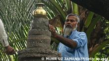 This picture taken on October 27, 2021 shows Muslim mason Taher Ali Khan working on a tomb at the Barisal Mahashashan Hindu crematorium ground in Barisal. - Bangladesh's minority Hindu community has endured waves of violence and persecution, but one Muslim artisan has devoted his talents to shepherding their dead along a peaceful journey to the next life. - TO GO WITH Bangladesh-religion-social-cemetery,FEATURE by Shafiqul ALAM (Photo by Munir uz zaman / AFP) / TO GO WITH Bangladesh-religion-social-cemetery,FEATURE by Shafiqul ALAM (Photo by MUNIR UZ ZAMAN/AFP via Getty Images)