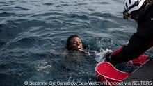 A member of German charity ship Sea-Watch 4's rescue team helps a migrant during a rescue operation in the Mediterranean Sea, November 18, 2021. Picture taken November 18, 2021. Suzanne De Carrasco/Sea-Watch/Handout via REUTERS ATTENTION EDITORS - THIS IMAGE HAS BEEN SUPPLIED BY A THIRD PARTY. MANDATORY CREDIT