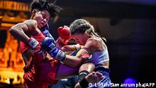 This photo taken on November 13, 2021 shows Muay Thai boxer Kullanat Ornok (L), fight name Nongnuk Rongriankilakorat, competing with Australian opponent Celest Hansen at Lumpinee Stadium in Bangkok. - Out with the gamblers and harsh neon lights, in with female fighters and fancy lasers -- after a 20-month coronavirus break, Thai kickboxing's spiritual home is embarking on a revolution. (Photo by Lillian SUWANRUMPHA / AFP) / TO GO WITH Box-Thailand-health-virus-pandemic, FOCUS