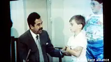 Saddam Hussein meets hostages. Iraqi President Saddam Hussein, moustagioed, speaks with Western (British) hostages as an Iraqi soldier pats a youth on the head, in these colors made off Iraqi TV Thursdayt. Iraqi TV brodcast the tape in an apparent attemp to show they are not being mistreated. (AP-Photo) 1990