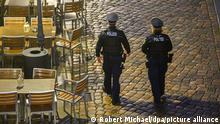 23.11.2021, Dresden - Polizisten laufen am Abend in der Dresdner Altstadt an Restaurants entlang. Die Polizeidirektion Dresden kontrolliert die Einhaltung der neuen Corona-Regeln täglich mit 50 Beamtinnen und Beamten. Im Fokus stehen demnach Kontrollen der FFP2-Maskenpflicht im öffentlichen Nahverkehr sowie die Ausgangsbeschränkungen für Ungeimpfte in Hotspot-Gebieten.