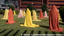 Transgender women stand under cloths as part of a performance titled Flower Garden by Guatemalan artist Regina Galindo in Guatemala City, Tuesday, Nov. 23, 2021. The performance was held in connection with the upcoming International Day for the Elimination of Violence Against Women observed on Nov. 25. (AP Photo/Moises Castillo)