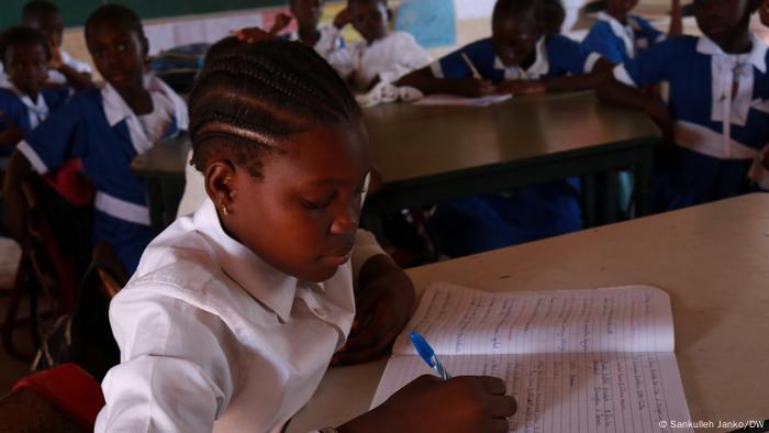 A girl in Gambia writes in her school book