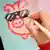 A hand drawing a digital pig with sunglasses that will be turned into a NFT, non-fungible token
