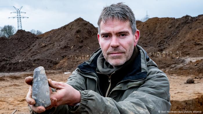 Ringo Kloss shows a stone ax found at the excavation site 