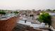 A woman paints her rooftop with solar reflective white paint in Ahmedabad, India