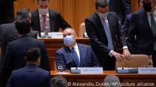 Romanian Prime Minister designate Nicolae Ciuca wears a mask before a parliament vote on his government team in Bucharest, Romania, Thursday, Nov. 25, 2021. Romanian lawmakers voted in favor of a new coalition government led by a Liberal former army general, which could usher in an end to a months-long political crisis in the Eastern European nation. (AP Photo/Alexandru Dobre)