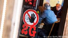 A '2G' rule sign, allowing only those vaccinated or recovered from the coronavirus disease (COVID-19) to enter indoor areas, is displayed at a window of a restaurant in Nuremberg, Germany, November 18, 2021. REUTERS/Lukas Barth