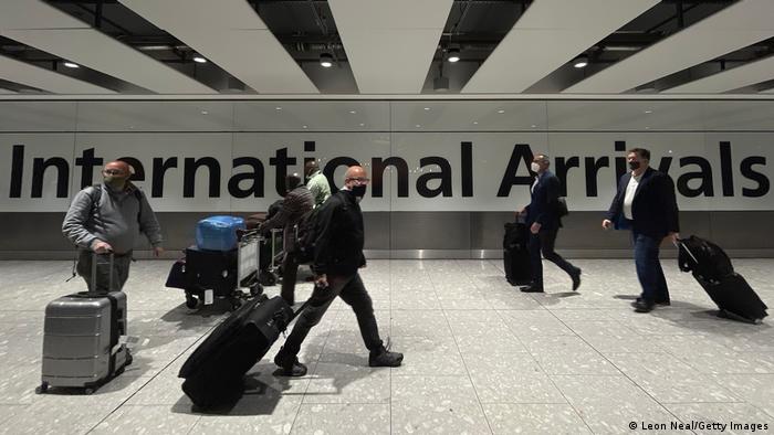 Travelers at London's Heathrow Airport, wearing masks