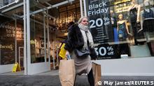 A customer walks with shopping bags outside a store on Black Friday in the West End shopping district of London, Britain, November 26, 2021. REUTERS/May James