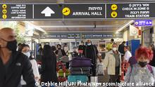 Travelers walk with their luggage outside Ben Gurion International Airport