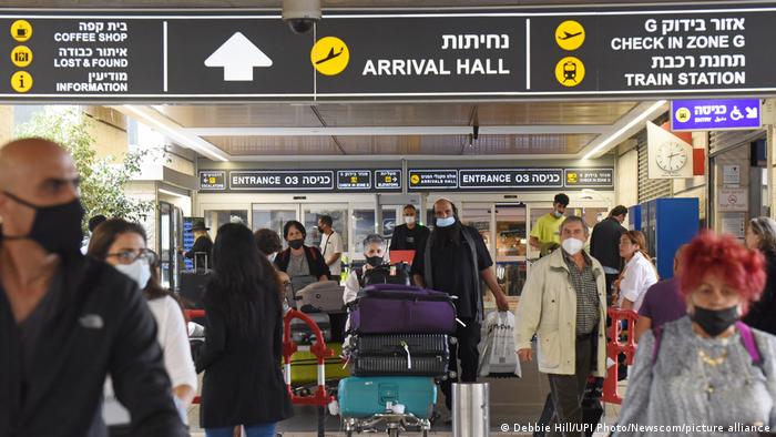 Travelers walk with their luggage outside Ben Gurion International Airport