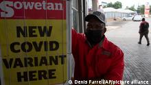 27.11.2021****A petrol attendant stands next to a newspaper headline in Pretoria, South Africa, Saturday, Nov. 27, 2021. As the world grapples with the emergence of the new variant of COVID-19, scientists in South Africa — where omicron was first identified — are scrambling to combat its spread across the country. (AP Photo/Denis Farrell)