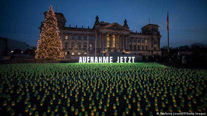 Un mar de luces verdes frente al Reichstag de Berlín llaman la atención sobre la situación de los migrantes en la frontera polaco-bielorrusa y piden que se los acoja.