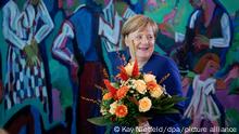 26.09.2018, Berlin: Bundeskanzlerin Angela Merkel (CDU) hält zu Beginn der Sitzung des Bundeskabinetts im Bundeskanzleramt einen Blumenstrauß in der Hand. Der Bundesminister für Verkehr und digitale Infrastruktur, Scheuer, bekam die Blumen zum Geburtstag. Foto: Kay Nietfeld/dpa +++ dpa-Bildfunk +++