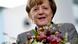 Angela Merkel holding a bunch of flowers, smiling Angela Merkel holding a bunch of flowers, smiling