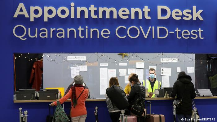 Passengers at a counter that says quarantine covid test