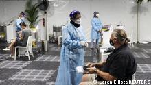 Travellers receive tests for the coronavirus disease (COVID-19) at a pre-departure testing facility, as countries react to the new coronavirus Omicron variant, outside the international terminal at Sydney Airport in Sydney, Australia, November 29, 2021. REUTERS/Loren Elliott