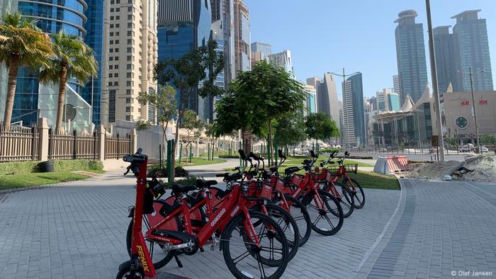 Eine Reihe von Mieträder mitten in Doha, im Hintergrund die Wolkenkratzer der Stadt Eine Reihe von Mieträder mitten in Doha, im Hintergrund die Wolkenkratzer der Stadt
