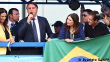 Brazilian President Jair Bolsonaro (L) delivers a speech to supporters in Brasilia after joining the right-wing Liberal Party (PL) on November 30, 2021, to seek reelection in the October 2022 polls. - Bolsonaro joined the PL to seek reelection in the October 2022 polls, despite not announcing his candidacy yet. Bolsonaro, who has been without a political party since 2019, was required to join one to run for the presidency as Brazilian laws bar independent candidacies. (Photo by EVARISTO SA / AFP)