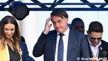 Brazilian President Jair Bolsonaro (C) gestures next to the Secretary of Government Flavia Arruda (L) in Brasilia after joining the right-wing Liberal Party (PL) on November 30, 2021, to seek reelection in the October 2022 polls. - Bolsonaro joined the PL to seek reelection in the October 2022 polls, despite not announcing his candidacy yet. Bolsonaro, who has been without a political party since 2019, was required to join one to run for the presidency as Brazilian laws bar independent candidacies. (Photo by EVARISTO SA / AFP)