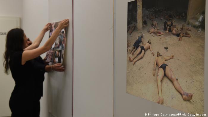 Members of the Syrian Organisation for the Victims of War (SOVW) display pictures documenting the torture of detainees inside the Assad regime's prisons and detention centers, on March 17, 2016, in Geneva. 