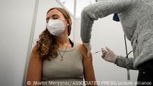 23.11.2021, Köln, Deutschland, A woman gets her vaccination at a vaccination Drive-in center in Cologne, Germany, Tuesday, Nov. 23, 2021. Germany battles rising numbers of coronavirus infections as a general COVID-19 vaccine requirement is widely discussed. (AP Photo/Martin Meissner)