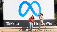 Facebook employees take a photo with the company's new name and logo outside its headquarters in Menlo Park, Calif., Thursday, Oct. 28, 2021, after the company announced that it is changing its name to Meta Platforms Inc. (AP Photo/Tony Avelar)