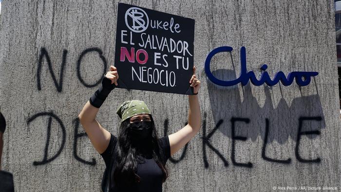A protester holding up a placard reading El Salvador is not your private business during demonstrations in San Salvador in September 2021