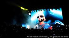 An avatar of El Salvador's President Nayib Bukele, is projected on a LED screen during the closing ceremony of a congress for cryptocurrency investors in Santa Maria Mizata, El Salvador, Saturday, Nov. 20, 2021. Bukele announced during the rock concert-like atmosphere at the gathering that his government will build an oceanside Bitcoin City at the base of a volcano. (AP Photo/Salvador Melendez)