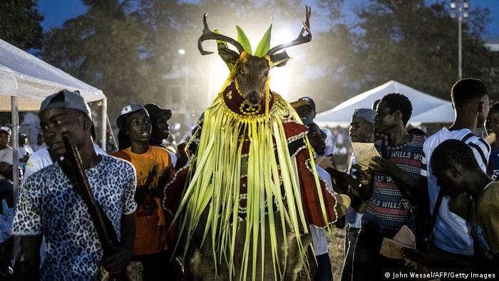 A man wears a traditional mask during the final campaign rally for the NPP in Banjul on December 2, 2021
