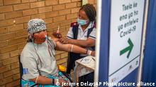 An Orange Farm, South Africa, resident receives her jab against COVID-19 Friday Dec. 3, 2021 at the Orange Farm multipurpose center. South Africa has accelerated its vaccination campaign a week after the discovery of the omicron variant of the coronavirus. (AP Photo/Jerome Delay)
