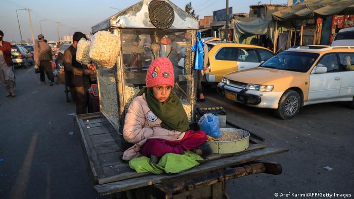 یک دختر خردسال روی یک گاری جواری فروشی در کابل نشسته است. احتمالا او پدر یا برادرش را همراهی می کند، شاید هم خودش کودکی کارگر باشد که در این روزهای سرد زمستانی در انتظار مشتری نشسته است.