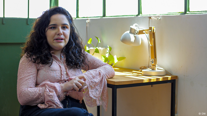 Ofelia Fernández, a woman with dark hair, is sitting at a table.