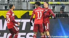 Bayern Munich's Polish forward Robert Lewandowski (R) celebrates scoring the 1-1 with his teammates Bayern Munich's French forward Kingsley Coman (C) and Bayern Munich's French midfielder Corentin Tolisso during the German first division Bundesliga football match BVB Borussia Dortmund v FC Bayern Munich in Dortmund, western Germany, on December 3, 2021. (Photo by Ina Fassbender / AFP) / DFL REGULATIONS PROHIBIT ANY USE OF PHOTOGRAPHS AS IMAGE SEQUENCES AND/OR QUASI-VIDEO
